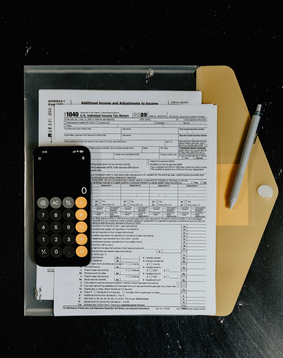 Form 1040 tax return with calculator and pen